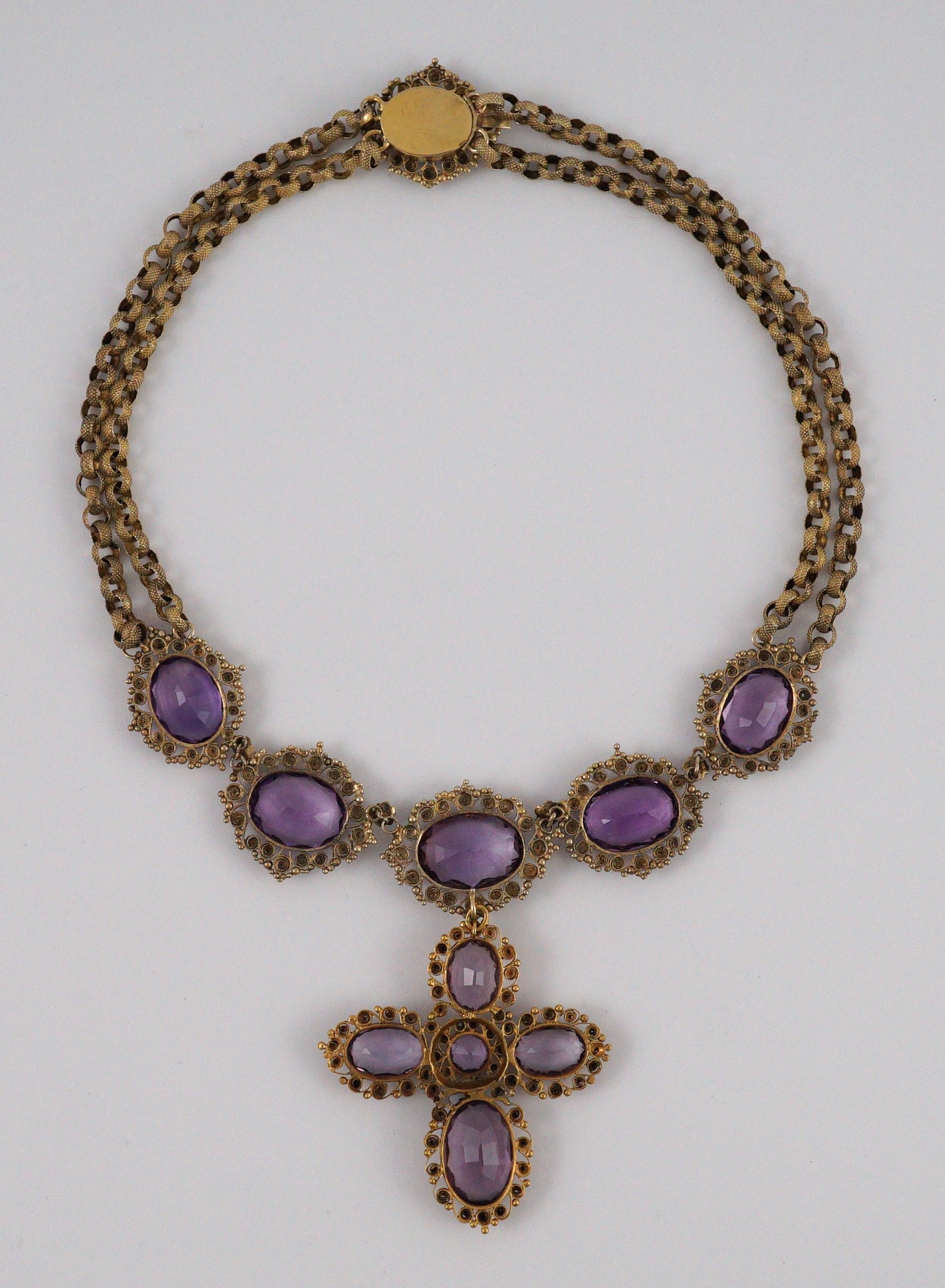 An early 19th century gold and eleven stone oval cut amethyst set pendant necklace and a similar cross pendant (repair)